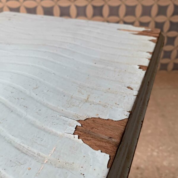 Detalla de algunos defectos antigua mesa pequeña con apartados bajo tablero